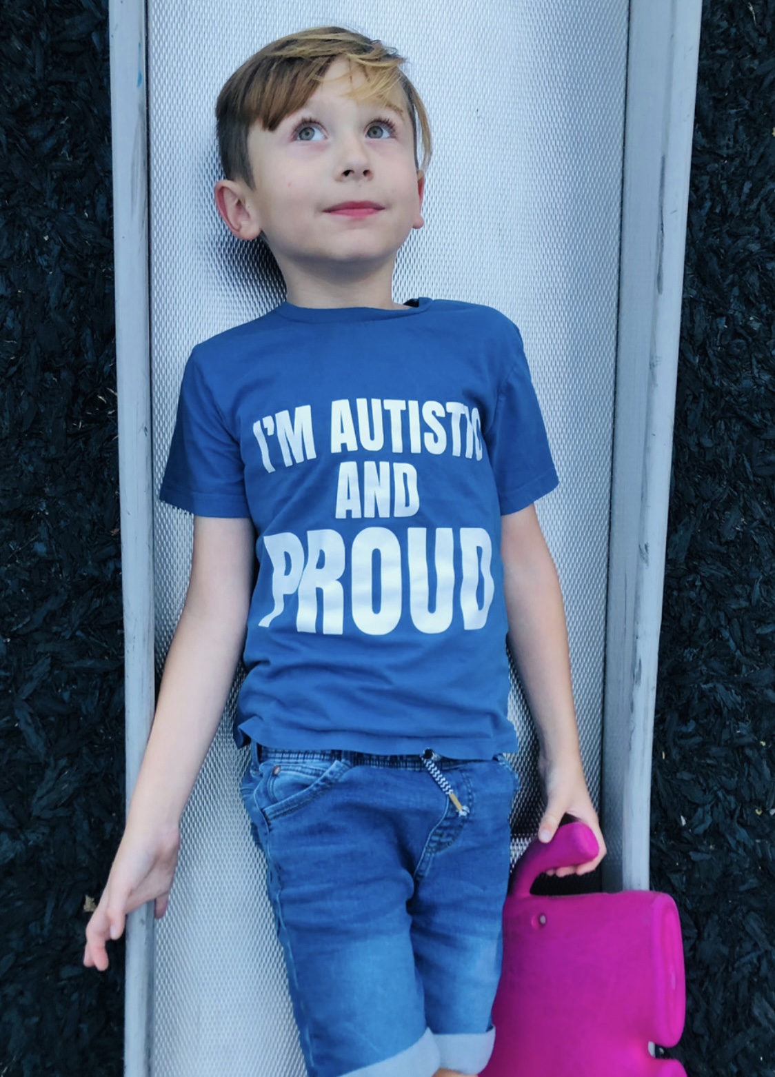 Oscar wears a blue t shirt which syas I'm autistic and proud in white writing 